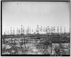 An oil field behind a grassy patch