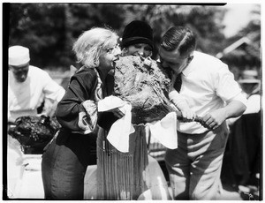 Two women and a man eating a roasted ostrich thigh in Lincoln Park