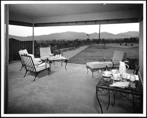 Furniture on the patio of a home, overlooking the mountains and back yard, ca.1950-1959