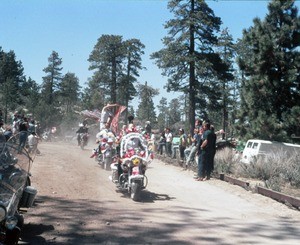 Parade of motorcycles with flowers and flags