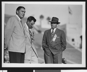 University of Southern California head football coach Jess Hill (right) talking to two other people at football pre-game practice at the Los Angeles Memorial Coliseum, 1951