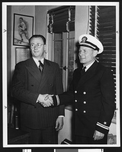 University of Southern California football coach Jeff Cravath shaking hands with Roy "Bullet" Baker, USC campus, 1944