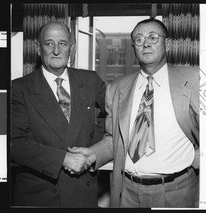 University of Southern California football coach Jeff Cravath shaking hands with Athletic Director Bill Hunter, probably after Cravath's resignation, USC campus, 1950