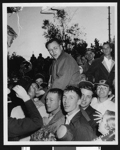 University of Southern California football coach Jeff Cravath being carried on top of celebrating students after the tie with Notre Dame, Los Angeles, 1948