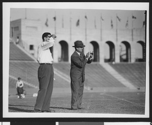 University of Southern California head football coach Jess Hill (right) clapping his hands at a football pre-game practice at the Los Angeles Memorial Coliseum, 1951