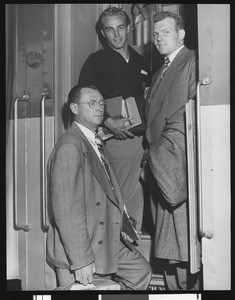 University of Southern California head football coach Jeff Cravath and USC players Dean Dill and Tony Linehan boarding a train, 1947