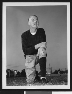 University of Southern California assistant football coach Sam Barry, on on knee, dark sweatshirt, Bovard Field, 1949