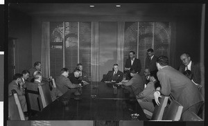 Press conference for new University of Southern California head football coach Jess Hill, with many reporters taking notes, January 1951