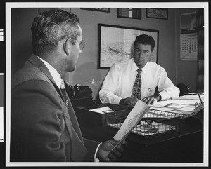 University of Southern California football coach Jess Hill talking to Assistant Athletic Director Alan Ewen in Ewen's office, August 1951