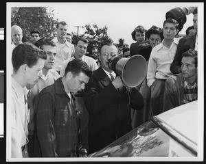 University of Southern California football coach Jeff Cravath speaking through a megaphone at student rally, USC campus, 1950