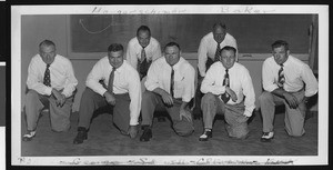 University of Southern California football coaching staff wearing white shirts and ties, 1949, USC campus classroom