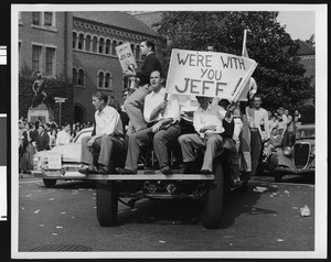 Student parade of cars and signs supporting University of Southern California football coach Jeff Cravath, USC campus, 1950