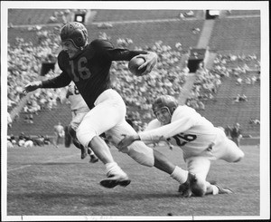 Frank Gifford freeing himself from tackling Johnny Williams in the final spring practice game, 1957