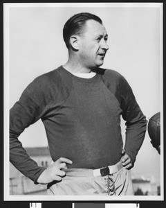 University of Southern California head football coach Jeff Cravath, hands on hips, wearing a dark sweatshirt. Bovard Field. 1947