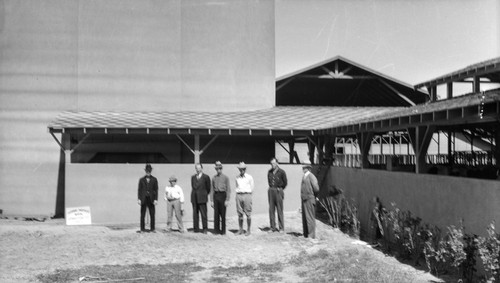 Men standing near building on school farm