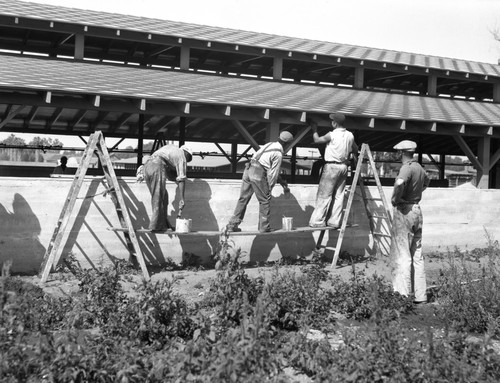 Students painting side of farm building