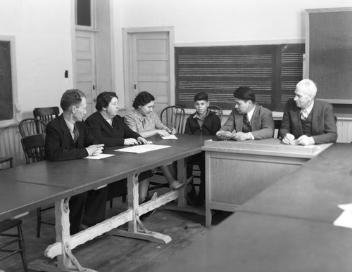 Faculty members and student at table