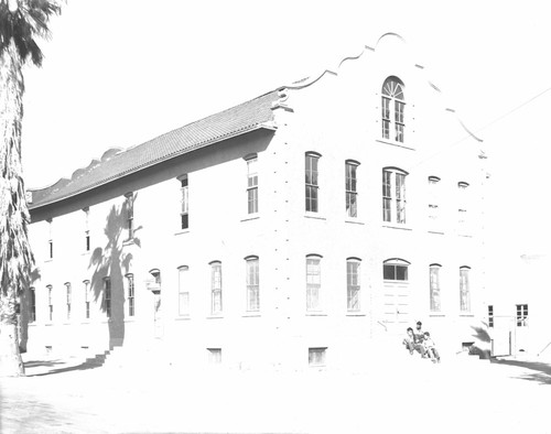 Students sitting on steps in front of building