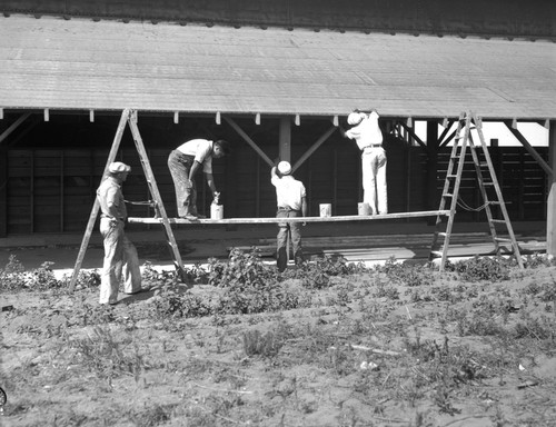 Students painting side of farm building