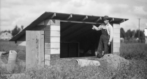 Student standing next to shed