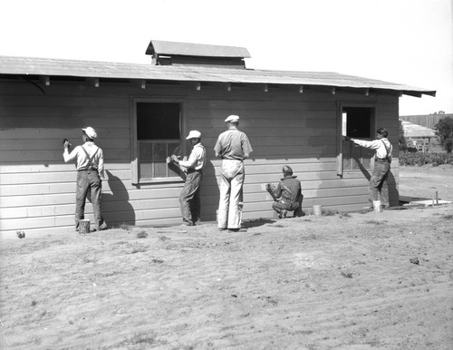 Students painting side of farm building