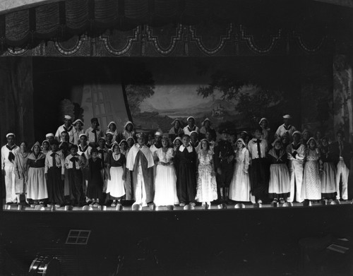 Students in costumes performing on stage