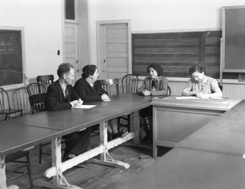 Faculty members and student at table