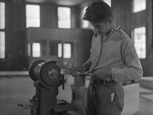 Student operates machine in shop class