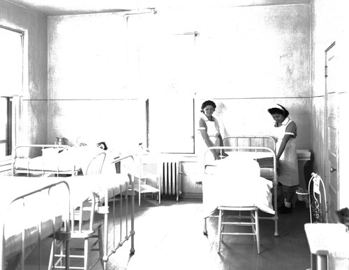 Student nurses making hospital bed