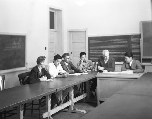Faculty members and student at table