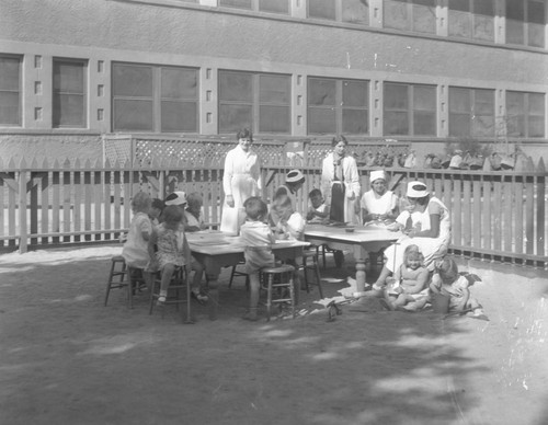 Students watching children play outside