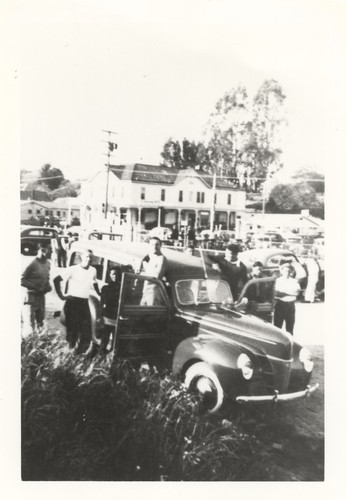 Eugene "Jeep" Allen, Fred Hunt, unidentified, Claude "Duke" Horan, three unidentified surfers in front of Woodie automobile at Cowell Beach