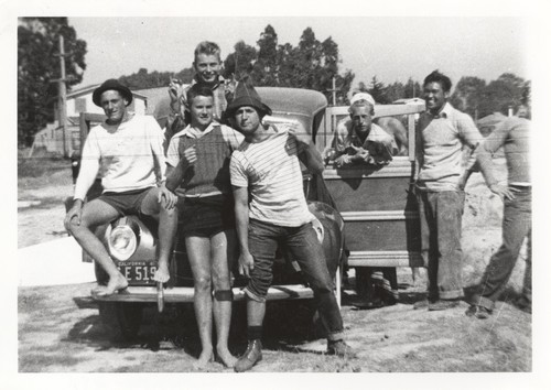 Jack Moore, Blake Turner, Rich Thompson, Bob Gillies, Harold Goody, Wataru Okino, (Ragon is behind Harold), Bill Grace stepping out of the picture. Group on "Woodie" automobile at Pleasure Point