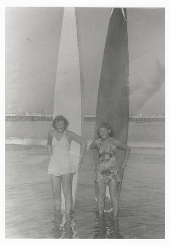 Pat Collings, Shirley Templeman standing in front of surfboards at Cowell Beach