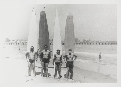 Alex Hokamp, Harry Mayo, Fred Hunt standing with surfboards at Cowell Beach