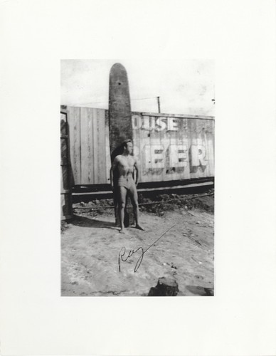 San Jose State Ray standing in front of surfboard