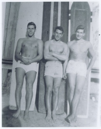 Terrence Hickey, Harry Mayo, Bob Rittenhouse standing in front of surfboards