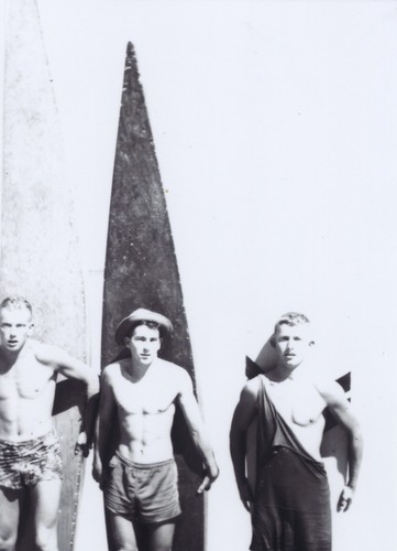 Rich Thompson, Harry Mayo, Bob Gillies in front of surfboards at Cowell Beach