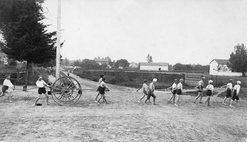 Boys pulling a hose cart