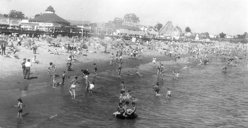 Swimmers and sunbathers on the beach by the Santa Cruz Boardwalk