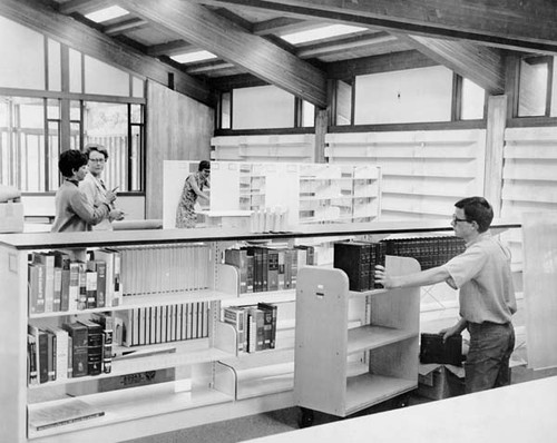 Staff shelving books before the opening of the Branciforte Library