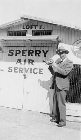 Man with a carrier pigeon in front of the Sperry Air Service Loft 1