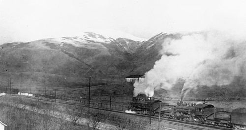 Train traveling by snow-covered Mount Pajaro