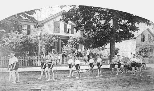 Boys pulling a fire hose cart