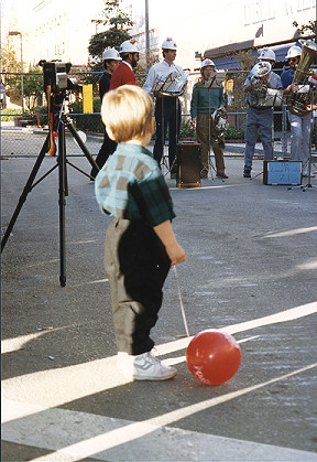 Boy with balloon and the hard hat brass band
