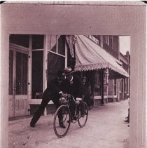 Thomas. Neville on bicycle & Ed Hotchkiss in front of Crews drug store