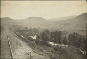 View down railroad tracks with a river on the right