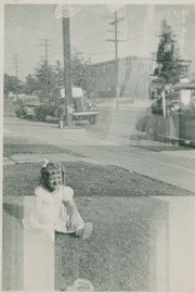 Child sitting on the front lawn, Boyle Heights, California