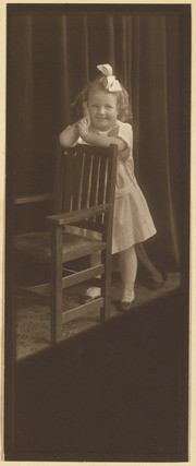 Ernestine Wood as a small child leaning on a chair