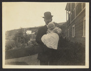 E. E. Wood and baby next to house